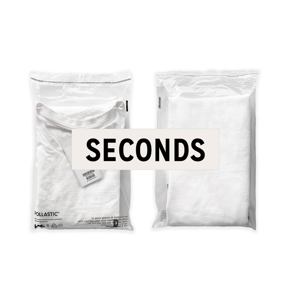 Front and back of a transparent Better Packaging POLLAST!C poly garment bag, containing a white tee shirt on a transparent background with a graphic label &quot;Seconds&quot;